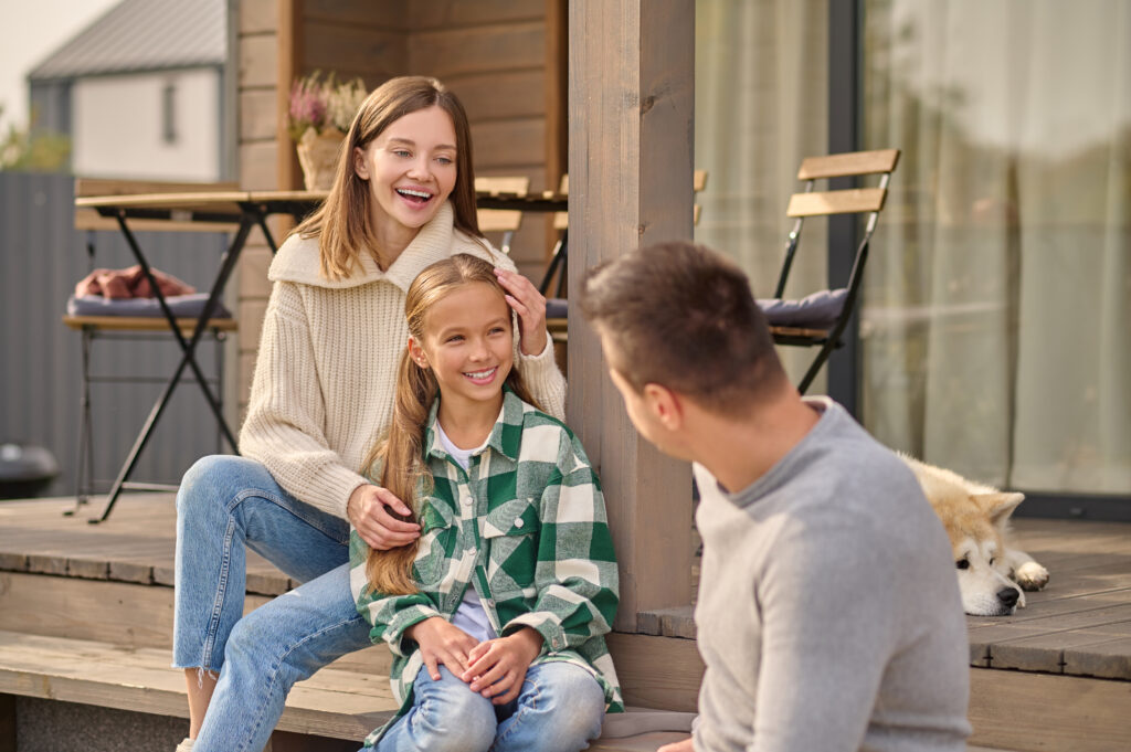 Family sitting outdoors talking and smiling