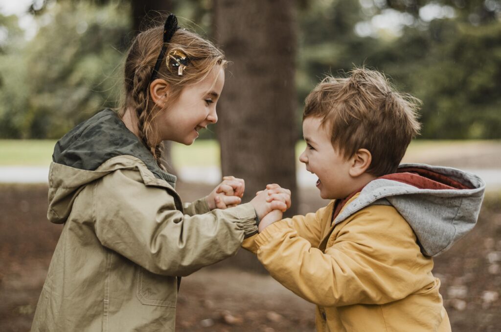Two children holding hands and laughing