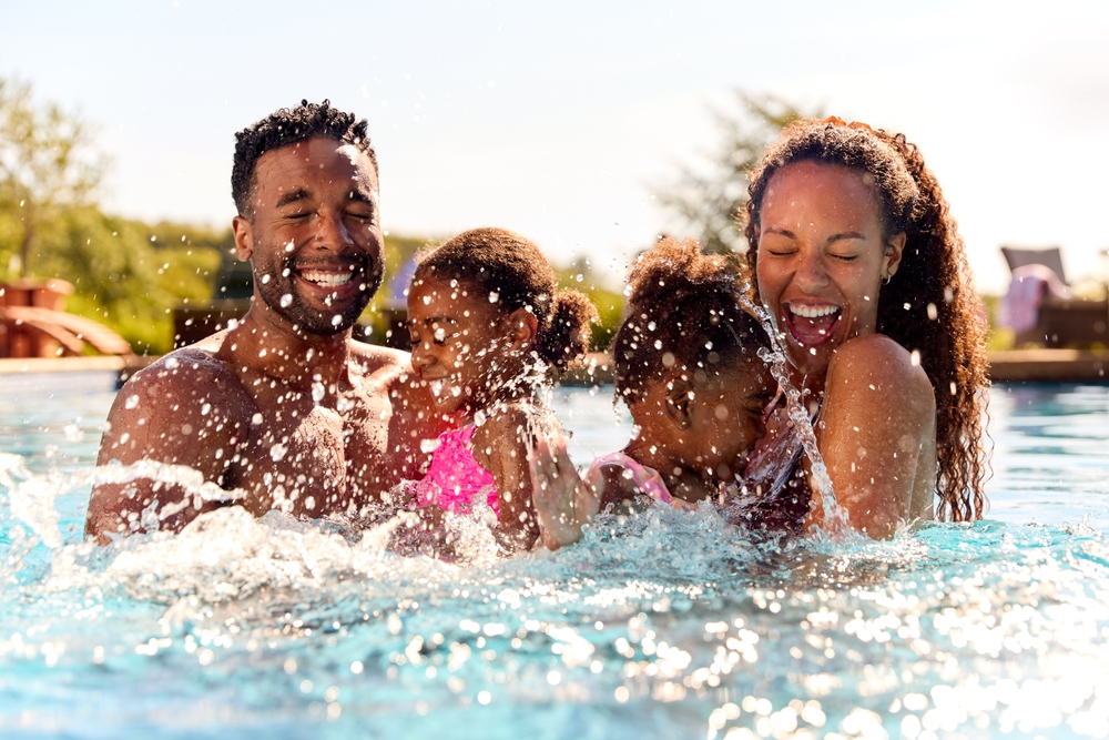 Family splashing together in a swimming pool
