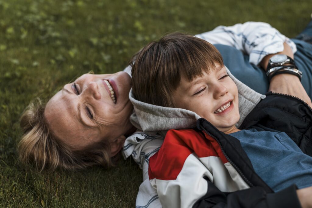 Woman and her son lying on grass laughing