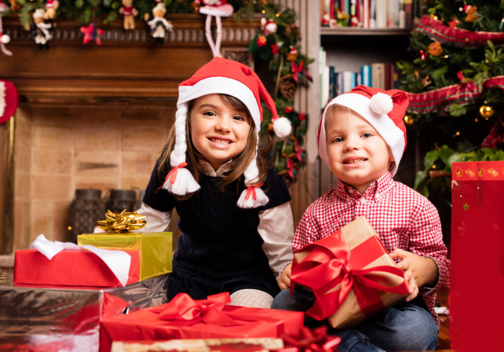 Boy and girl smiling with Christmas gifts