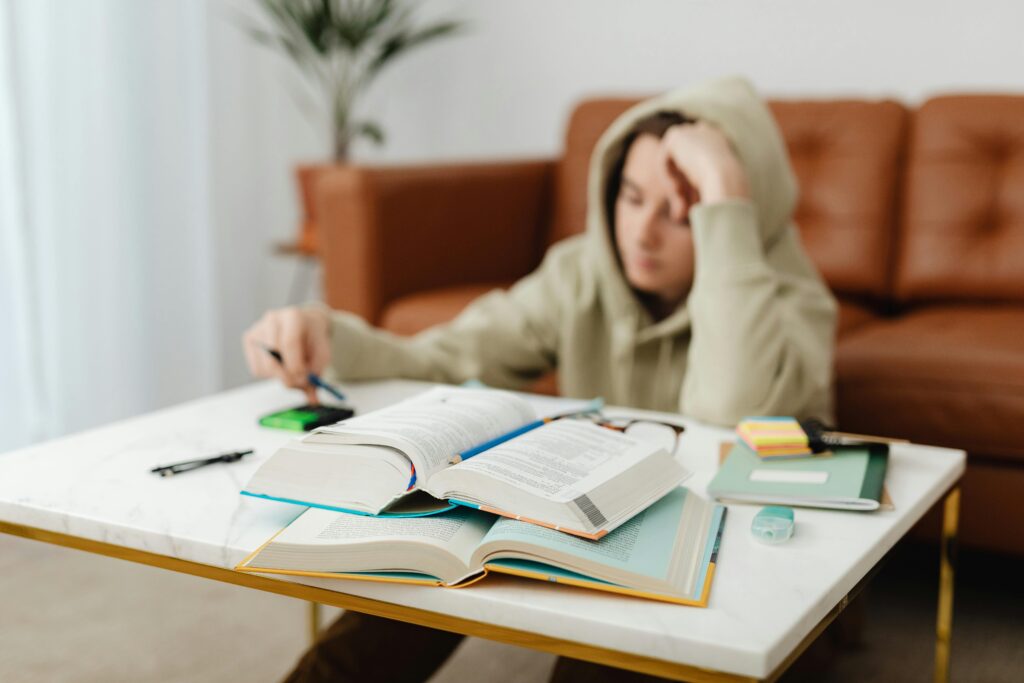 View of books with teenage boy in the background